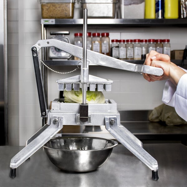 A person using a Global Solutions by Nemco square lettuce cutter to press vegetables.