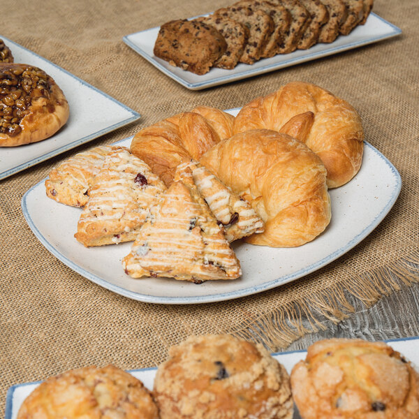 A rectangular porcelain platter with a variety of pastries on it.