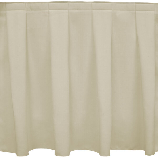 A beige table skirt with a box pleat pattern.
