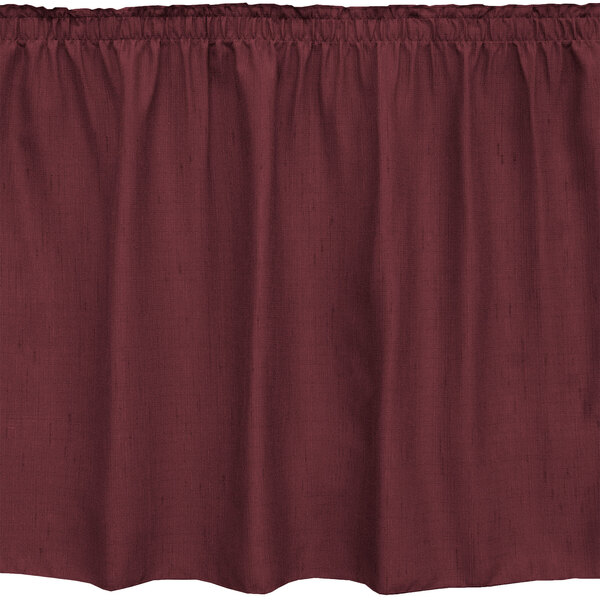 A burgundy table skirt with ruffles on the edge.