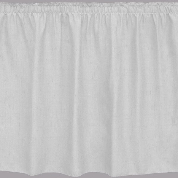 A white table skirt with shirred pleats on the edges.