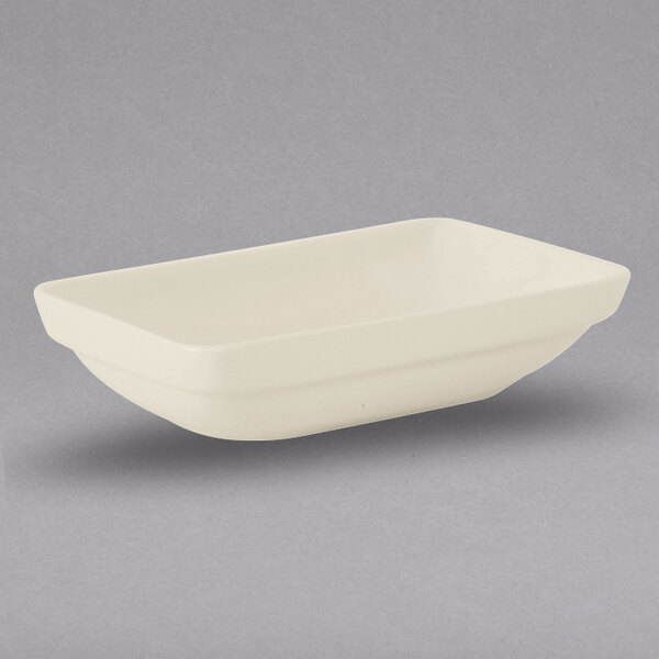 A white rectangular Tuxton china bowl on a gray background.