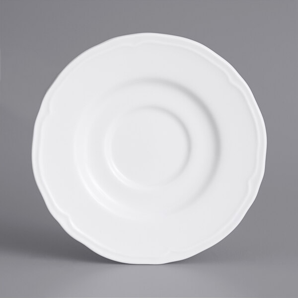 A Tuxton Charleston bright white china demitasse saucer with a scalloped edge.