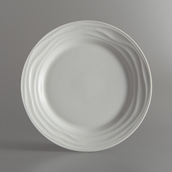 A close-up of a Tuxton TuxTrendz Sandbar bright white china plate with wavy lines.