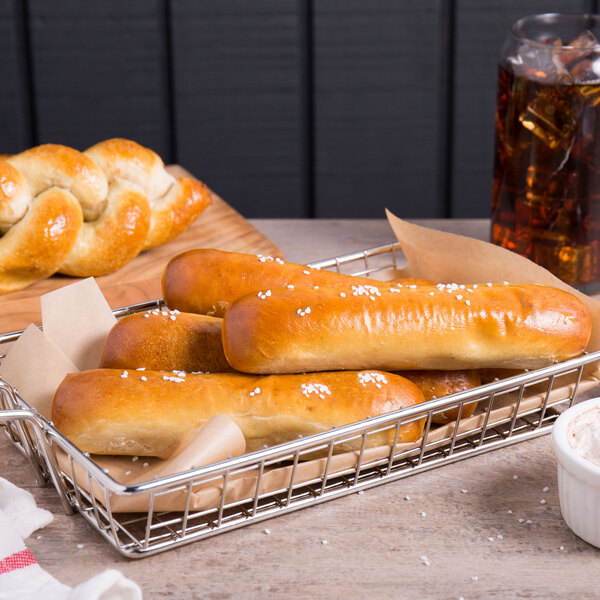 A basket filled with Dutch Country Foods soft pretzel sticks on a table in a bakery display.