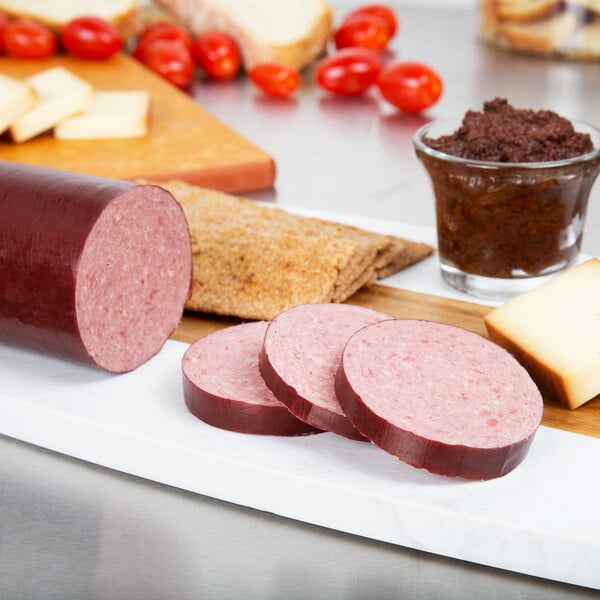 Sliced beef summer sausage and cheese on a cutting board.