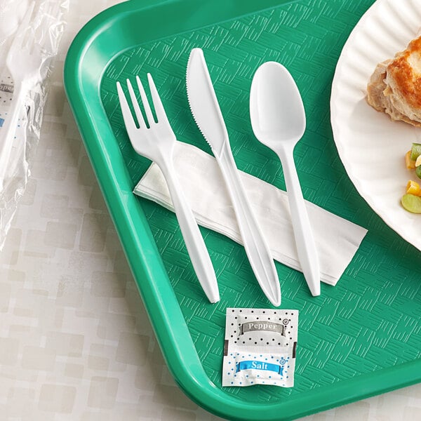 A white plastic tray with wrapped white plastic cutlery, a napkin, and salt and pepper packs.