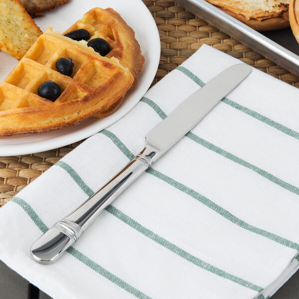 A Oneida stainless steel table knife on a plate with a waffle and blueberries.