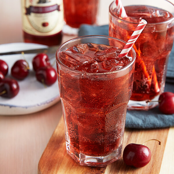 A glass of Reading Soda Works Black Cherry with ice and a straw.