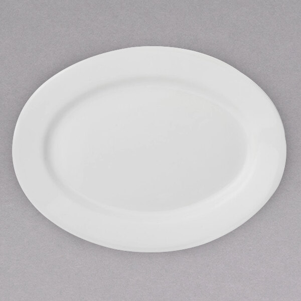 A white Arcoroc porcelain oval platter on a gray surface.