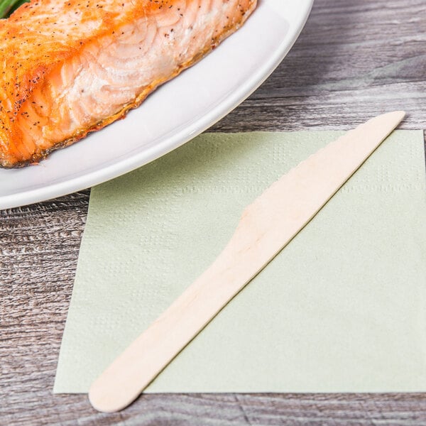 A plate of fish with an Eco-gecko wooden knife on a napkin.