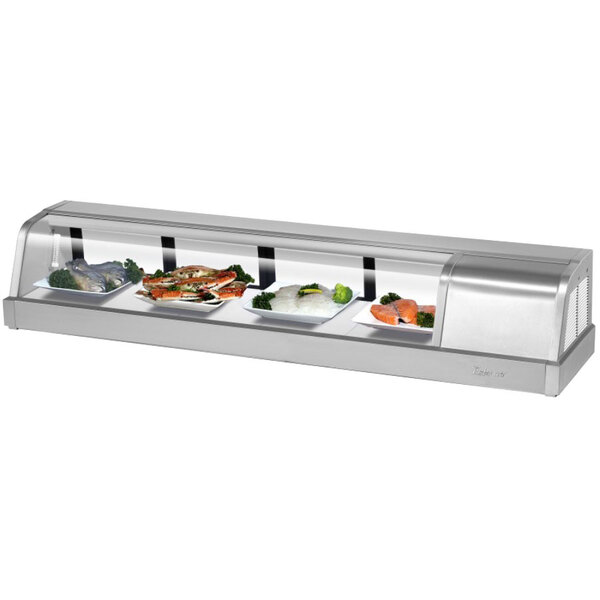 A Turbo Air stainless steel refrigerated sushi case with curved glass displaying food.