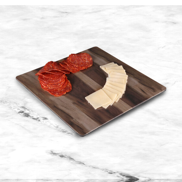An Elite Global Solutions faux hickory wood melamine serving board with slices of meat and cheese.
