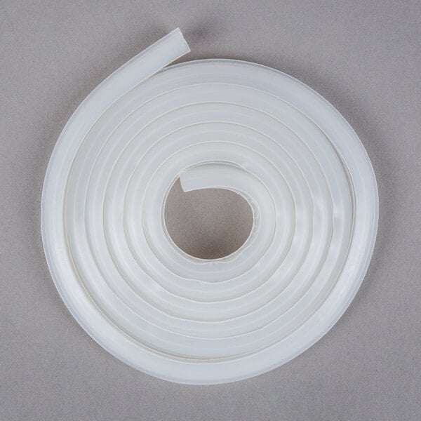 A white flexible tube with a white plastic tube on a gray surface.