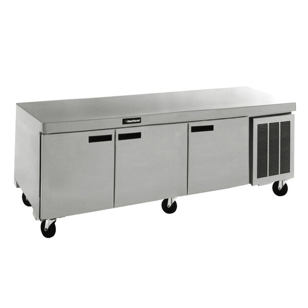 A Delfield stainless steel undercounter refrigerator with 3 doors on wheels.
