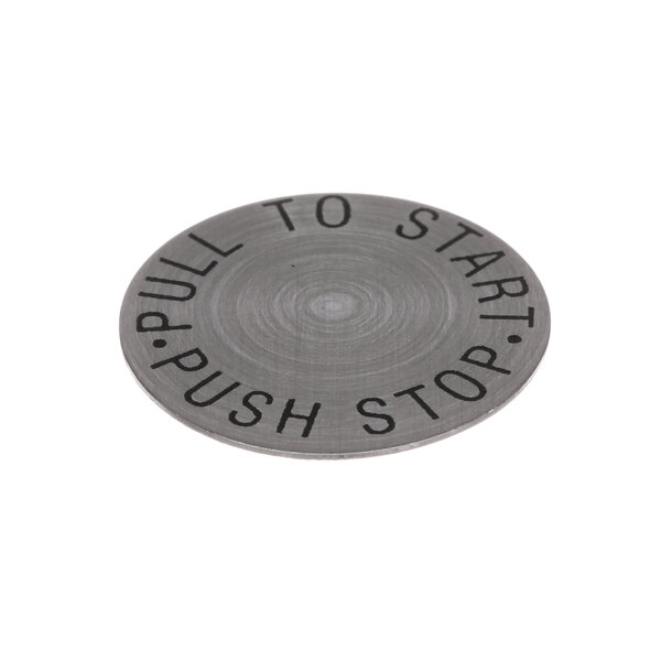 A close-up of a Hobart circular metal disc insert with words on it.