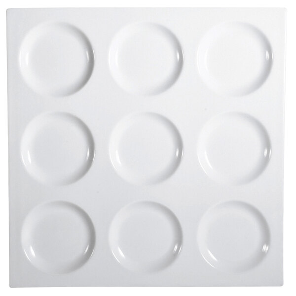 A bright white porcelain square tray with 9 circular compartments.