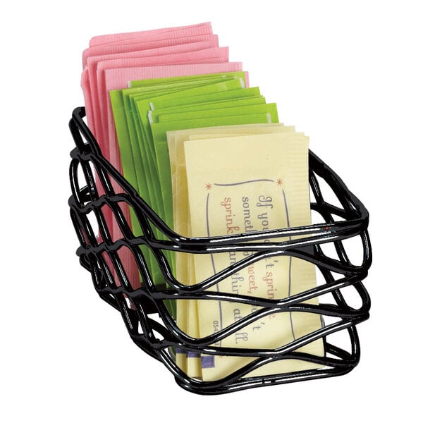 An American Metalcraft black wire basket with several sugar packets inside.