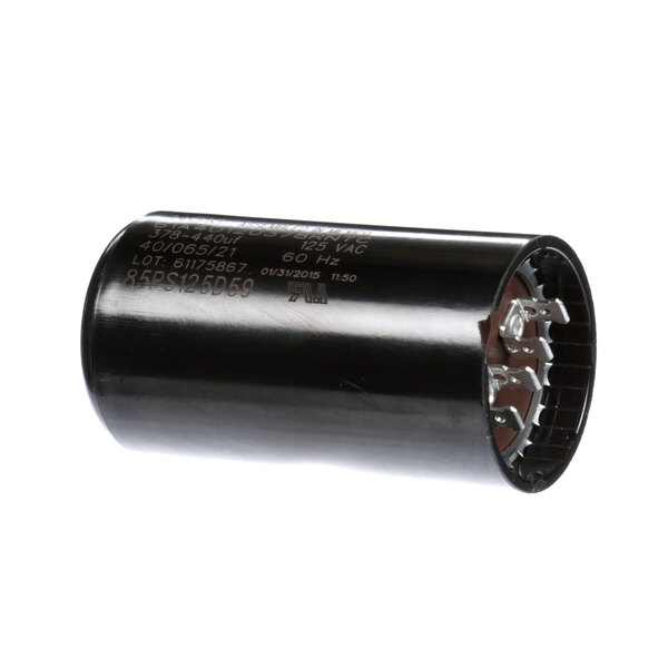 A close-up of a black round Follett Corporation capacitor.