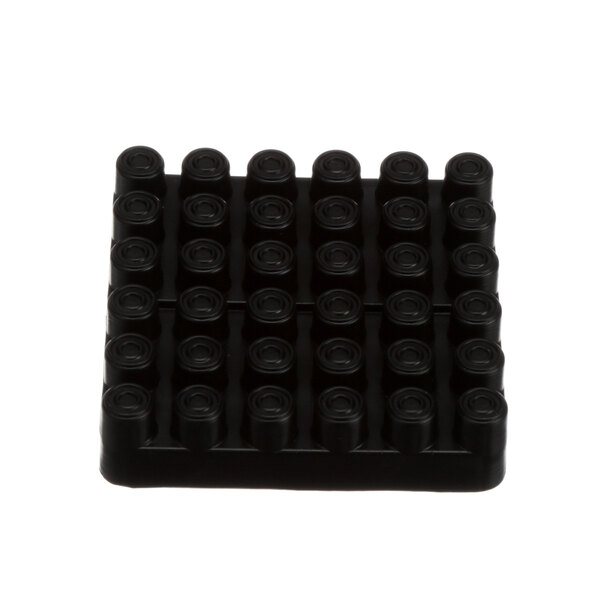 A black plastic square with eight round black circles.