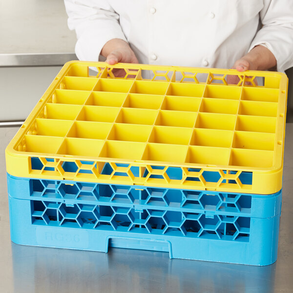 A chef holding a yellow Carlisle glass rack extender.