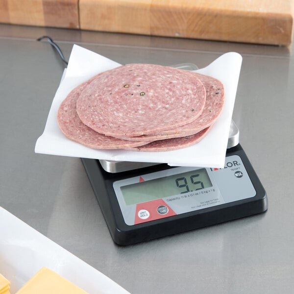 A Taylor digital portion scale with meat slices on it.