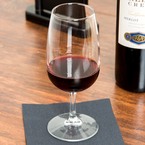 A Libbey Vina wine glass filled with red wine on a table.