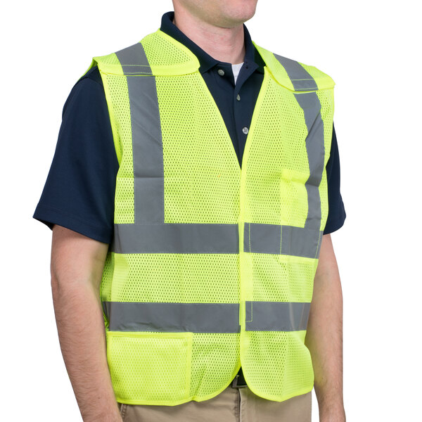 A man wearing a Cordova lime high visibility safety vest over a yellow vest.