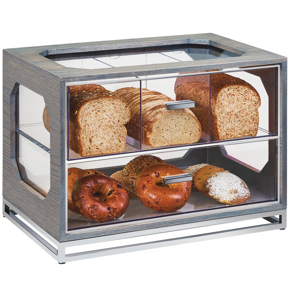 A Cal-Mil Ashwood wood and glass bakery display case with bread and bagels inside.