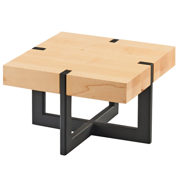 A Cal-Mil square maple riser on a wooden table with black metal legs.