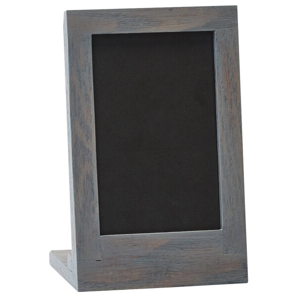 A wooden frame with a black chalkboard on a stand.