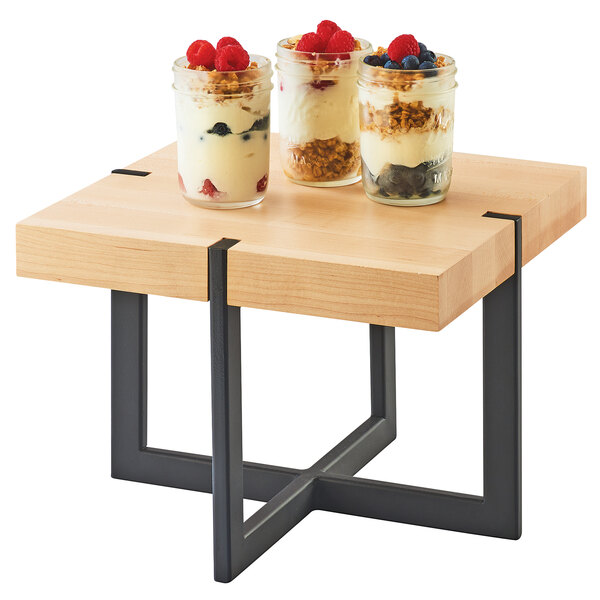 A Cal-Mil square maple riser on a table with jars of desserts.