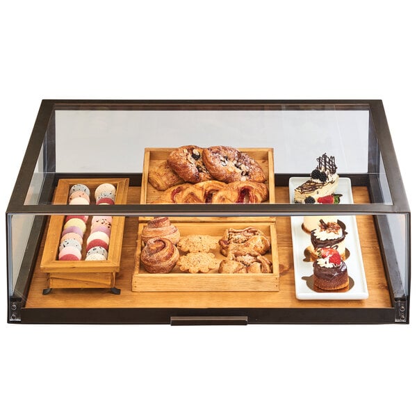A Cal-Mil pastry drawer display case filled with pastries on a table.