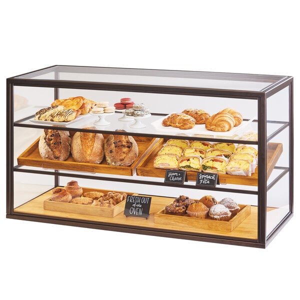 A Cal-Mil Sierra display case on a counter filled with bread and pastries.