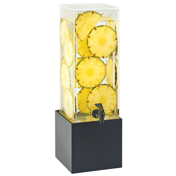 A Cal-Mil bamboo beverage dispenser filled with water and slices of pineapple.