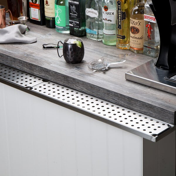A Regency stainless steel underbar mount beer drip tray on a bar counter.