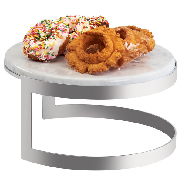 A Cal-Mil Ashwood marble riser on a table with a group of donuts.