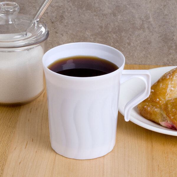 A white Fineline plastic coffee mug on a plate with a pastry.