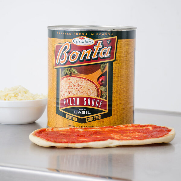 A can of Bonta pizza sauce on a table with a pizza.
