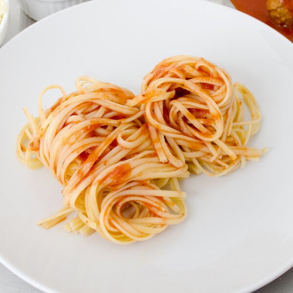 A white plate of Napoli linguine with tomato sauce.