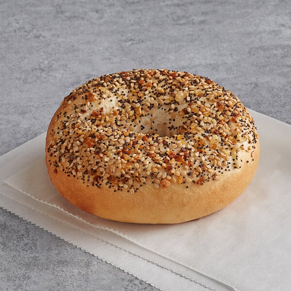 An Original New York Style Everything Bagel with seeds on top sitting on a napkin.