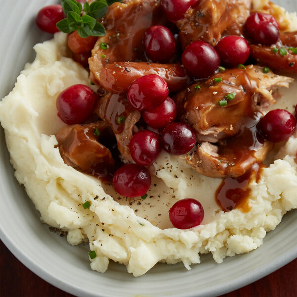 A plate of mashed potatoes with meat and IQF frozen cranberries.