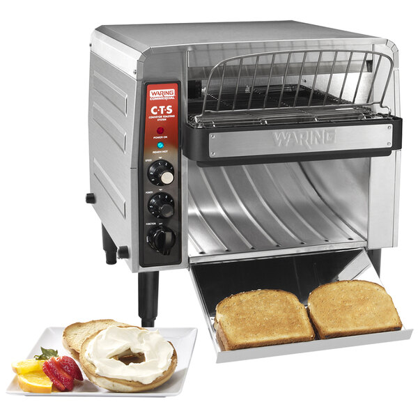 A Waring commercial conveyor toaster with a tray of toast.