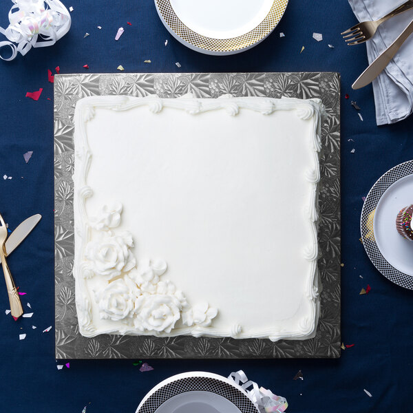 A white square cake on a black Enjay cake board.