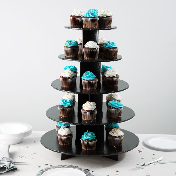 An Enjay black tiered cupcake stand with cupcakes on it.
