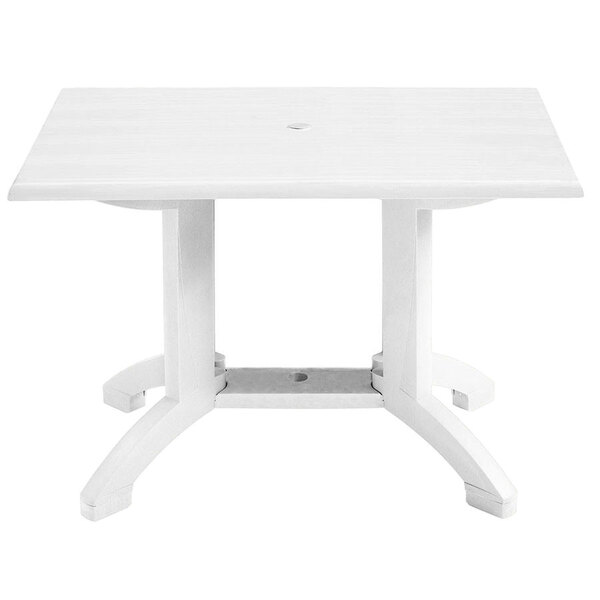 A Grosfillex white rectangular pedestal table with legs.