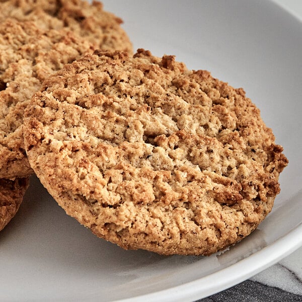 A close up of three Keebler Oatmeal Cookies on a white plate.