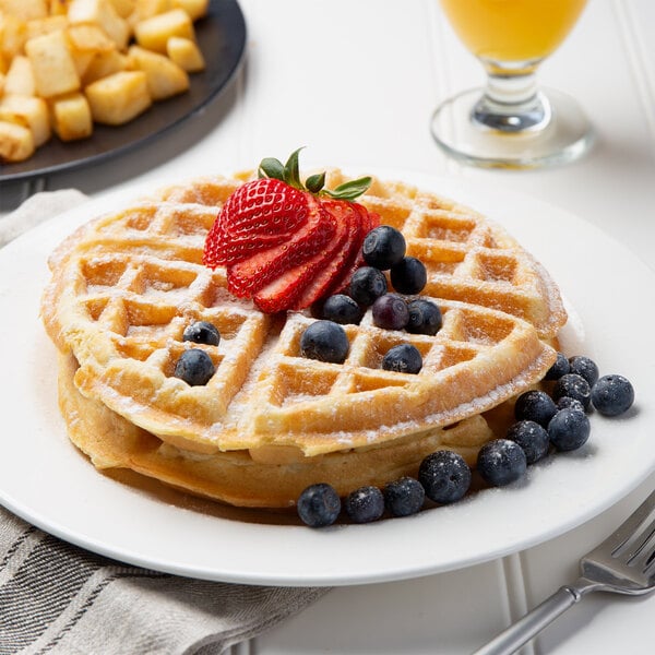 A Krusteaz Belgian waffle with strawberries and blueberries on a plate.