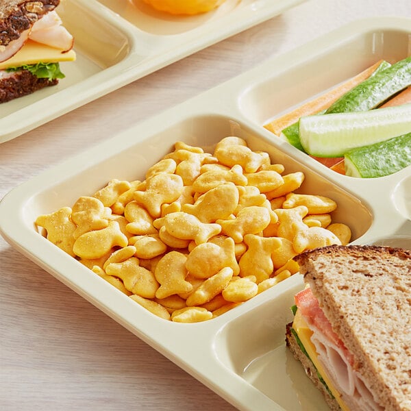 A tray of Pepperidge Farm Goldfish Cheddar Crackers with a sandwich and salad on it.