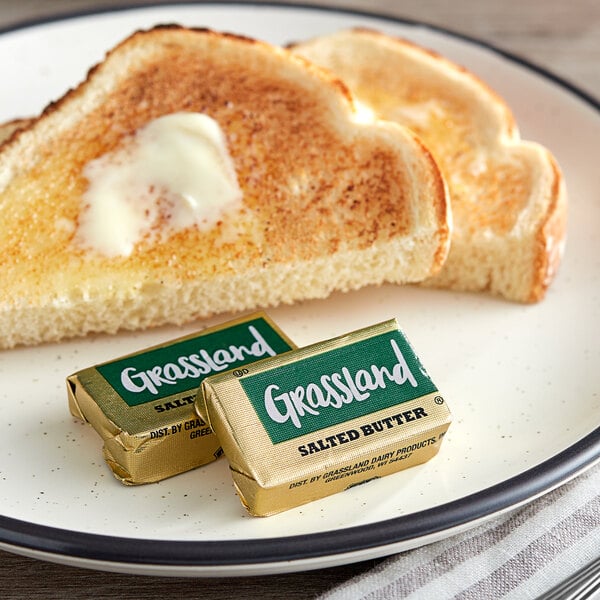 A piece of toast with Grassland butter on a plate.
